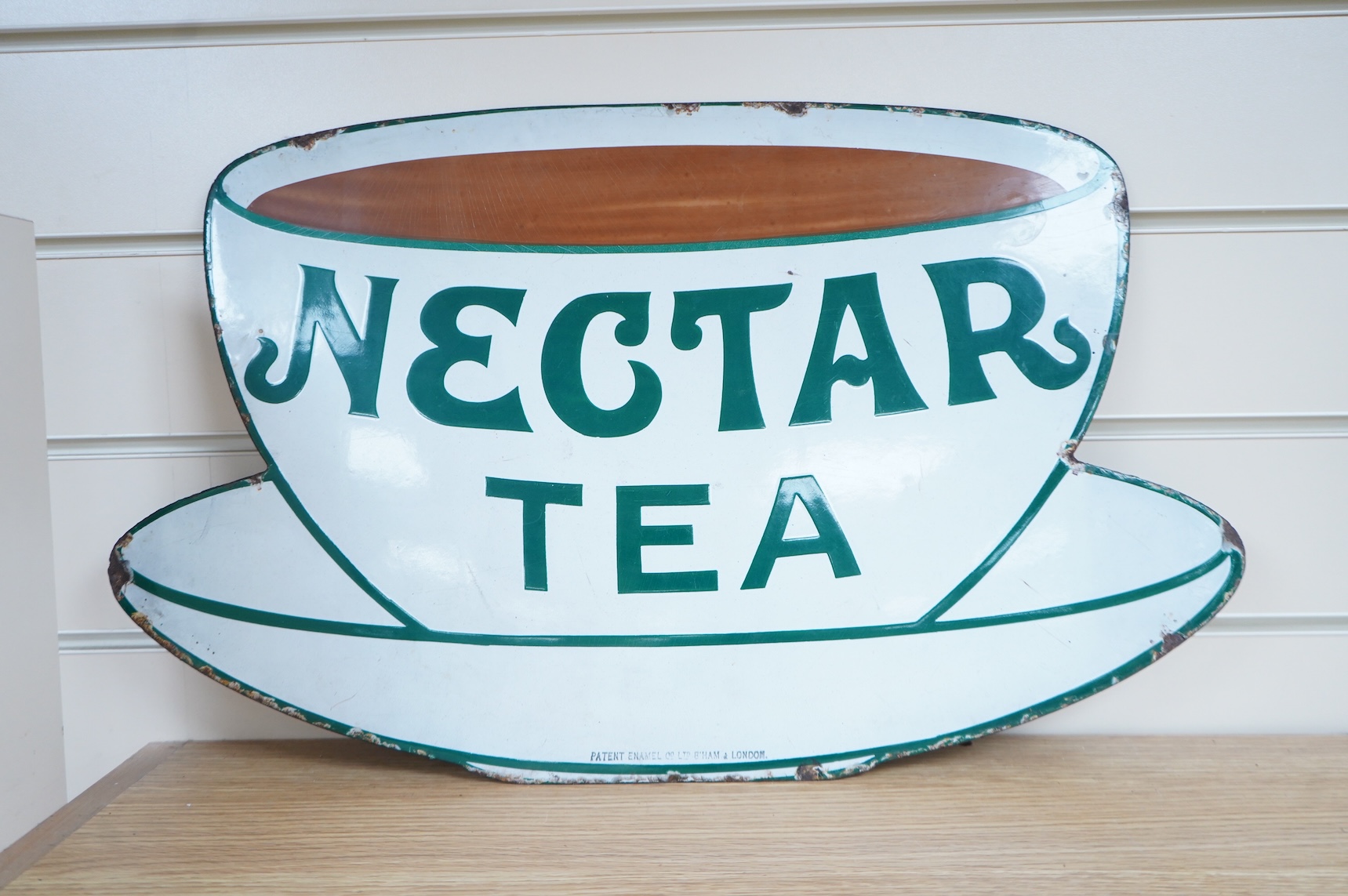 Two Nectar Tea enamel advertising signs, both with original ‘Directions for Hanging’ labels pasted onto the reverse with an allocation for Waterloo Station, one also with a W.H. Smith luggage label for ‘Derby For Repairs